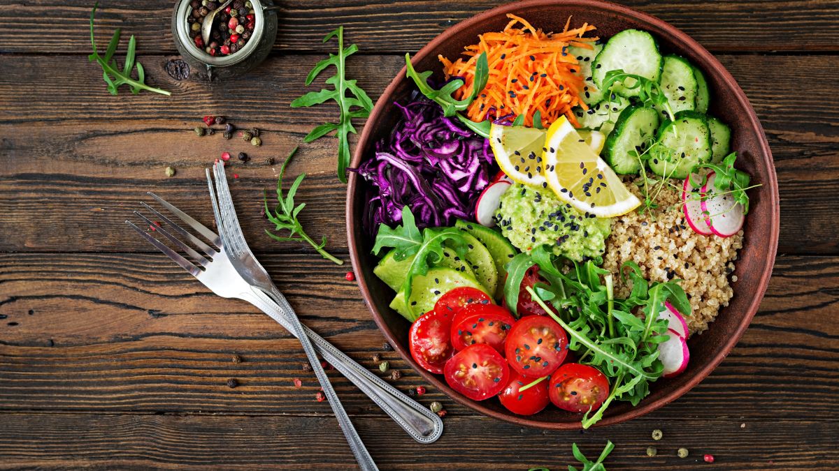 Színes vegetáriánus saláta quinoa, zöldségek és citromszeletek társaságában.